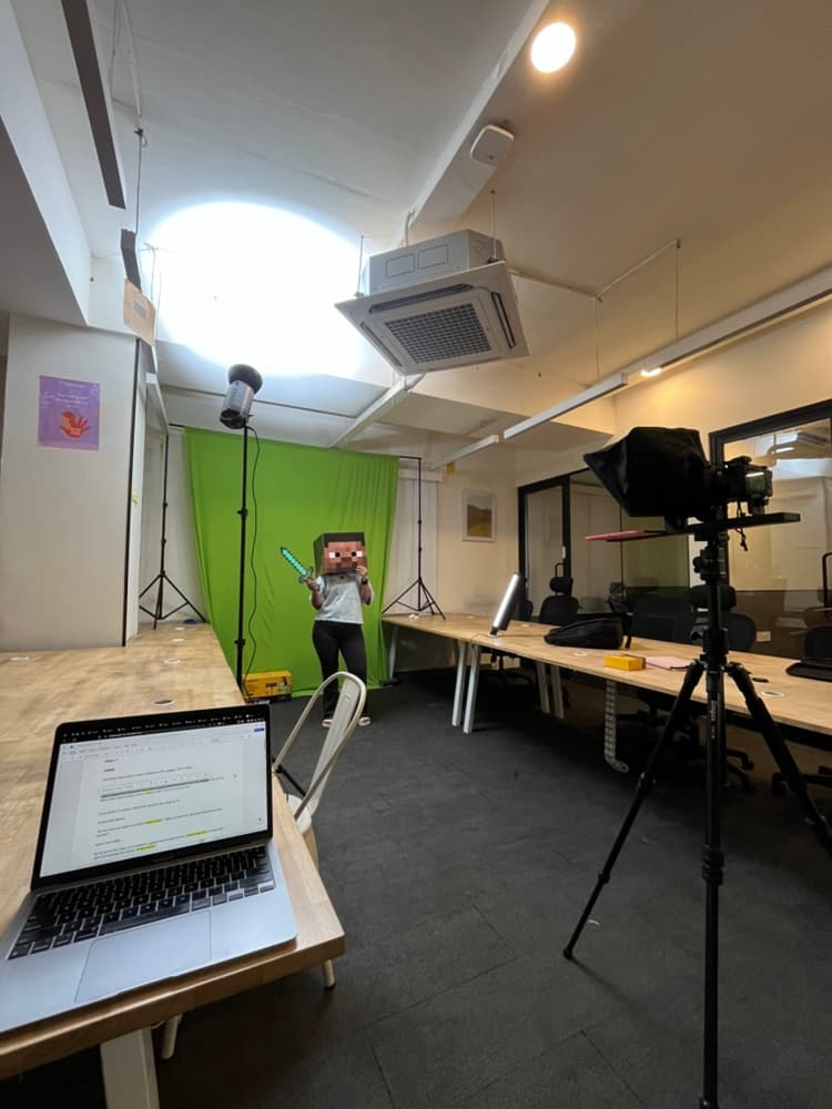 CodeYoung green-screen production setup with camera, lighting, and script laptop